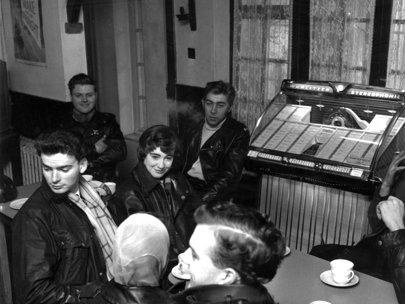 A group of bikers drinking coffee in a roadside cafe in 1960