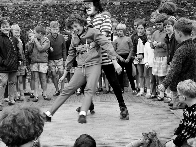 A clown on roller skates providing entertainment at the Dunbar Trader's Association Baby Show in August 1961.
