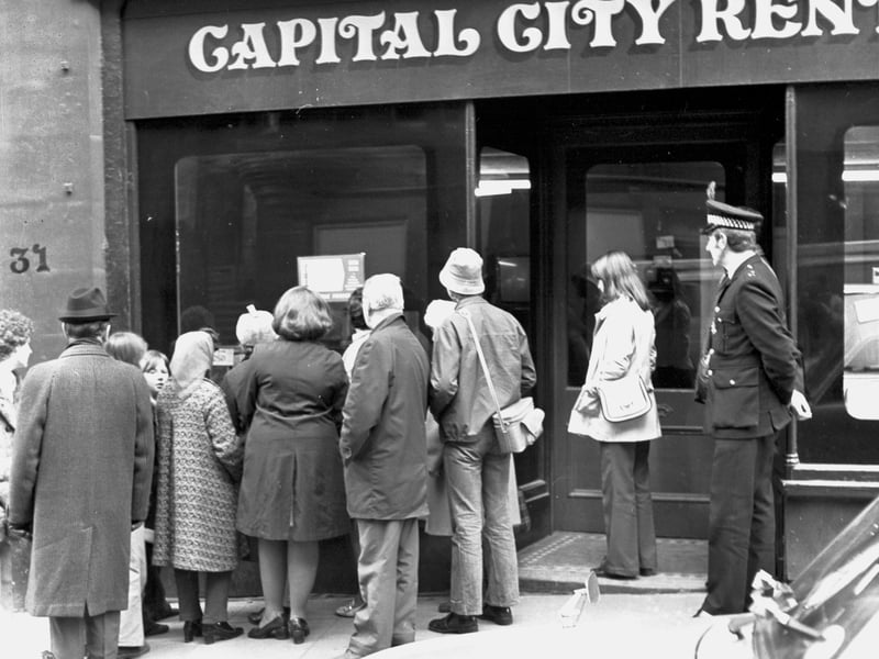 Passersby watch the royal wedding of Princess Anne and Captain Mark Phillips in a television shop window on Edinburgh's Royal Mile in November 1973