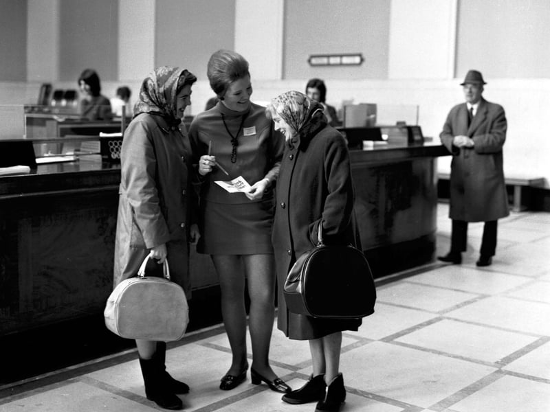 Two women have the new decimal system explained to them by a 'Decimal Dolly' inside the Edinburgh Savings Bank in February 1971