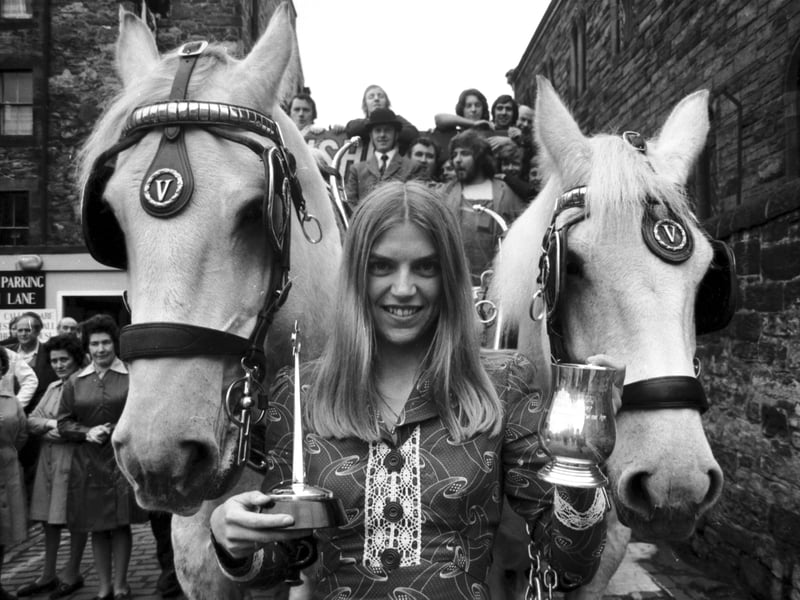 Scottish athlete Helen Golden receives the Usher-Vaux Sportswoman of the Year Award for 1973, beside a brewer's dray outside the brewery, in October 1974