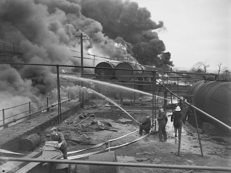 Men spray water from a on to a fire at the Scottish Tar Works, Falkirk, in 1973, as smoke billows into the sky