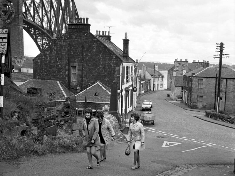 A group of women walk up a lane in North Queensferry in July 1972, with the Forth Bridge in the background
