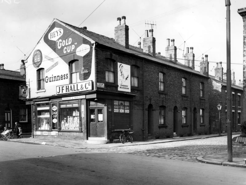 On the left is Oldfield Street, next on Oldfield Lane numbers 88/90. This is a grocers and off licence shop belonging to J.F. Hall and Co. The name Reg. Stevens is also over the shop. Topham Street is on the right. Pictured in November 1964.