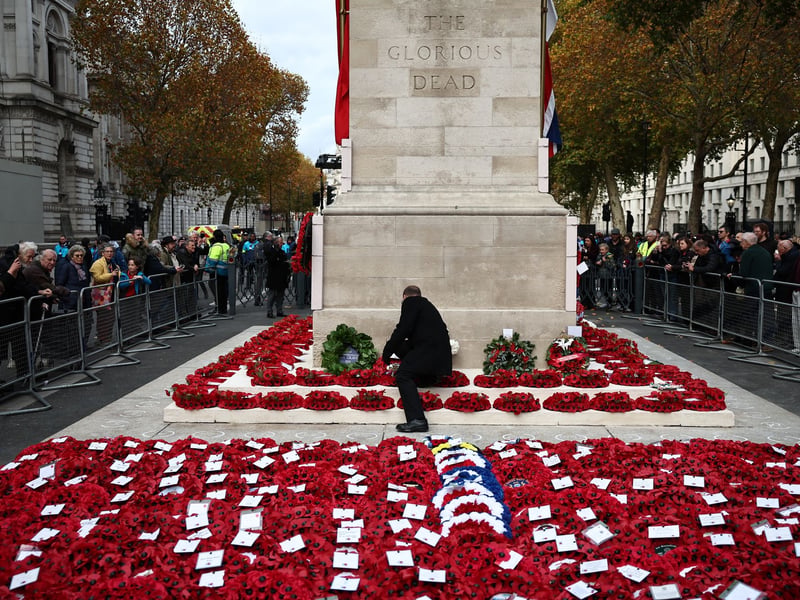 People watch as the wreaths are organised at the foot of the Cenotaph on Whitehall in London.