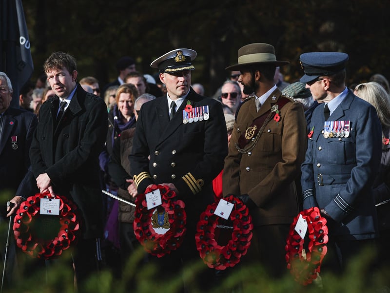 Servicemen representing the Royal Navy, the Army and Royal Air Force gather at the war memorial with their poppies in Hartley Wintney, west of London, during a Remembrance service.