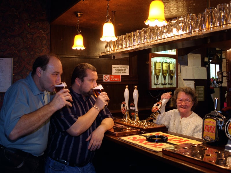 Betty Sharp pulling a pint at the Grey Goose pub watched by left, barman Mick Auty and landlord Carl Ward.