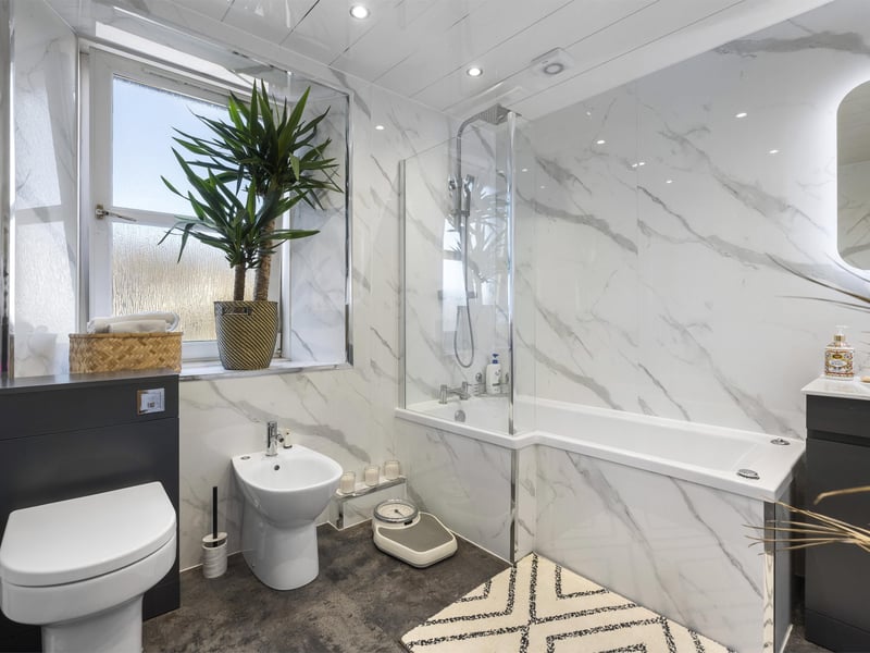 The contemporary family bathroom is finished to a high standard with a bath and separate shower.