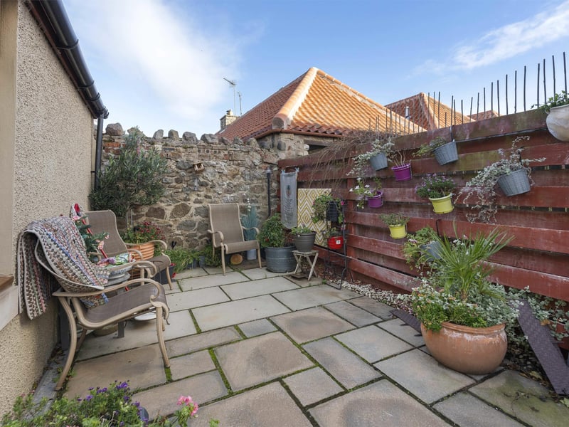 Externally, the property features an enclosed garden with a paved patio area ideal for outdoor dining and relaxation.