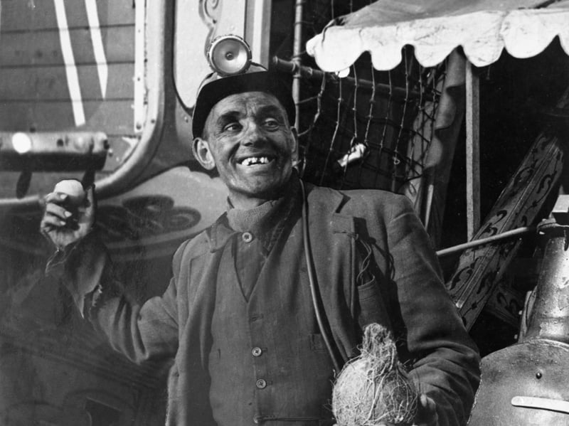 A miner tries his luck at the coconut shy at the Good Friday Fair in Conisbrough, South Yorkshire, in 1955