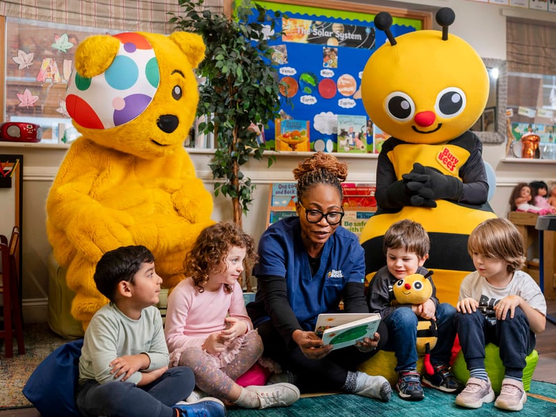 The children enjoy story time with Pudsey Bear and Busy Bee.