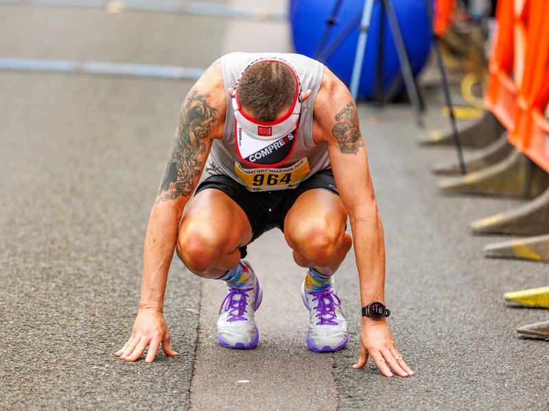 A runner recovers at the finish line of the Gosport Half Marathon 2025.