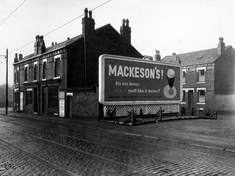 A view from Compton Road looking towards Compton Place on the right. A large billboard for Mackeson's stout is in the centre. The tram tracks on Compton Road can be seen in the foreground. The road leads to Stanley Road on the left. Pictured in November 1952.