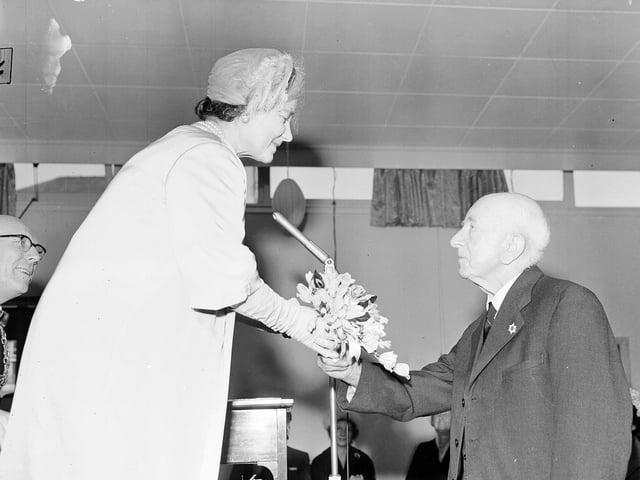 The Queen Mother being presented with a a bouquet at an Old People's Club during a visit to Dundee in October 1959.