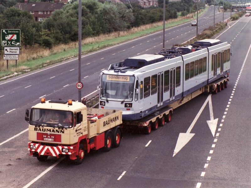 A Supertram arrives in Sheffield on the back of a low loader and heads down the Parkway to the tram depot on Nunnery Lane, off Woodbourn Road, in August 1993