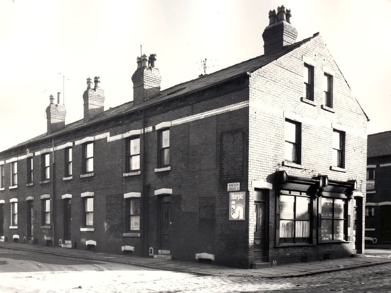 Back-to-back properties on Nineveh Grove run from the left edge of this view, houses are single fronted and numbers 16 to 10 can be seen. On the right are two shops number 19, then number 21 Nineveh Avenue.