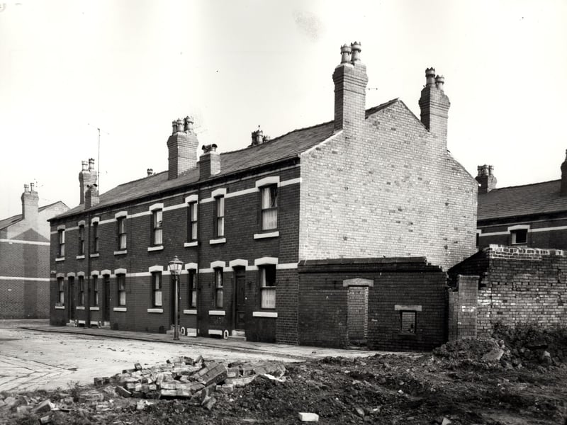 This view looks across a construction site onto a block of four back-to-back properties on Meynell Street, numbers run from 36 to 30, left to right. The majority of houses on Meynell Street had previously been demolished. At the time of this view Holbeck was in the process of regeneration.