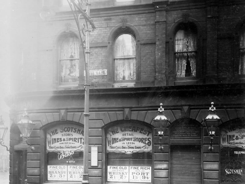 Call Lane numbers 1 - 3, showing Scotsman Stores which sold wine and spirits. Ornamental lamps on either side of doorway. Prices of spirits in windows.