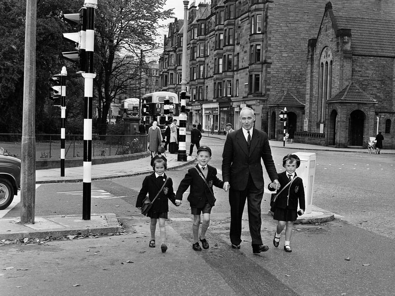 Councillor John Fitzpatrick helps children over the road at Holy Corner in 1964.