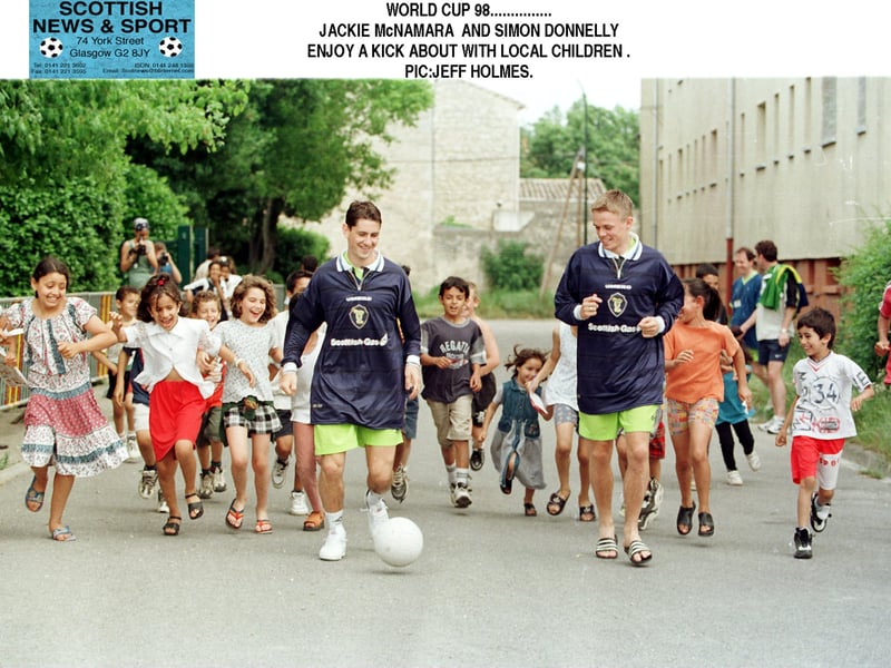 Scotland's Simon Donnelly and Jackie McNamara enjoy a kickabout with local kids.