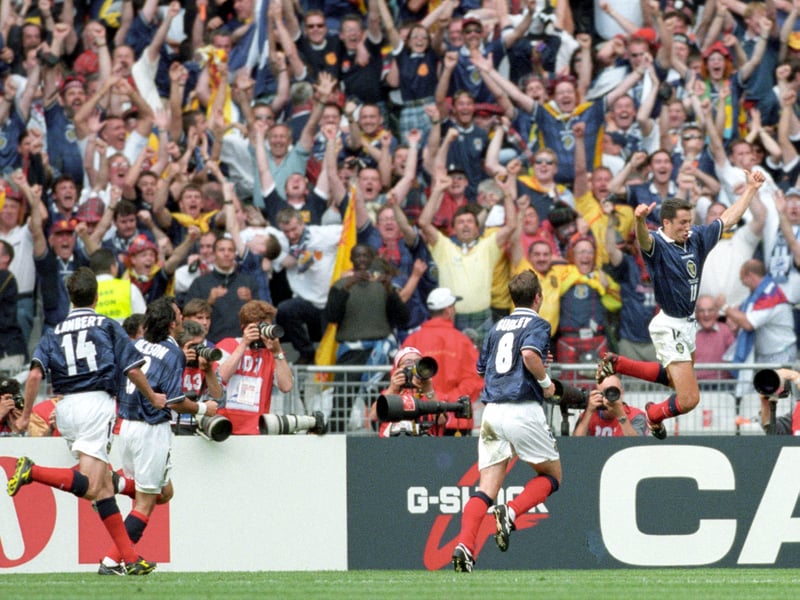 John Collins leads the celebrations in front of the Scotland fans after equalising from the penalty spot.