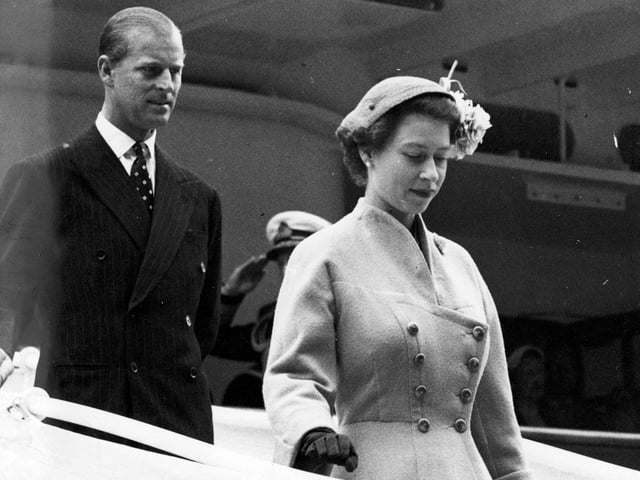 Queen Elizabeth II and Prince Charles walk down the gangway of the Royal Yacht Britannia at Aberdeen in August 1955.