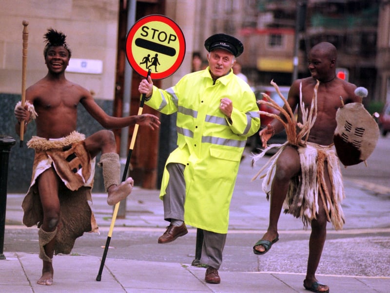 Lollipop man George Davidson has a dance with NASA performers from Zimbabwe, Thando Mpofu, Mathius Zulu and Owen Ncube, in 1998