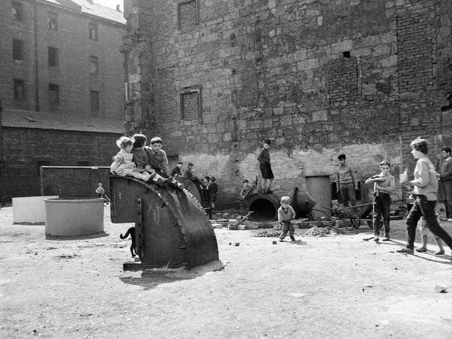 Children play in waste ground after removal of old buildings in Glasgow in July 1961.