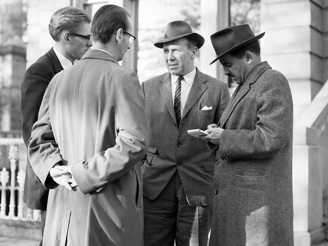 Matt Busby of Manchester United FC (second right) interviewed by reporters outside SFA Head Quarters in Park Gardens in Glasgow in October 1958.