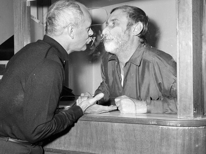 Spike Milligan hams it up with fellow performer Bill Kerr in the box office at the Alhambra Theatre in Glasgow in July 1967.