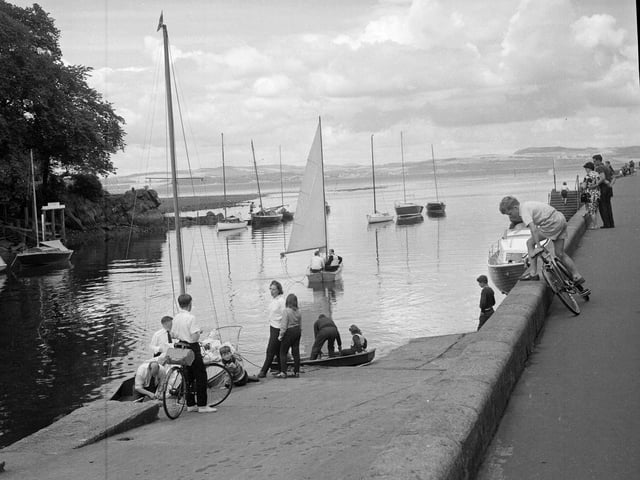 A yachtsman guides his craft down river past the old white houses at Cramond in July 1964.