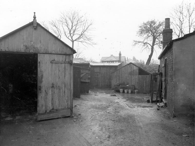 Station Road Improvement area showing yard with brick and wooden sheds. In the yard are buckets and brooms. Pictured in October 1937.