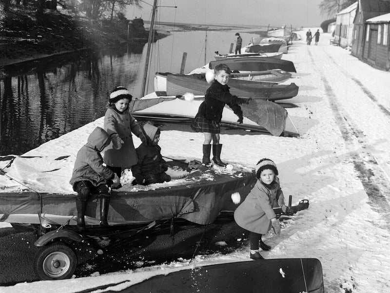 Children playing on the snow-covered boats at Cramond in February 1963.