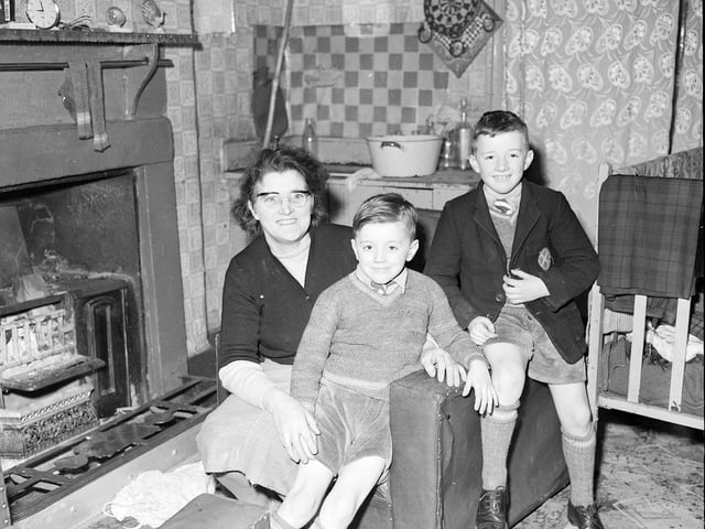 Bridget McGeever and her two sons sitting in front of the grate of their Leith Walk home in February 1960.