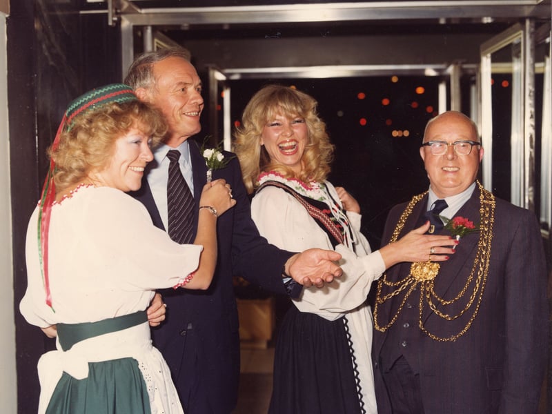 The Lord Mayors of the twinned cities of Leeds and Dortmund are pictured receiving carnation boutonnieres from two ladies dressed in German national costume.