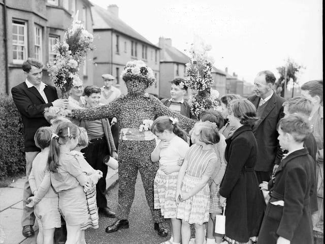 The burryman Mr J Hast leaves his home to go round the town in his fancy dress for the South Queensferry fair in August 1960.