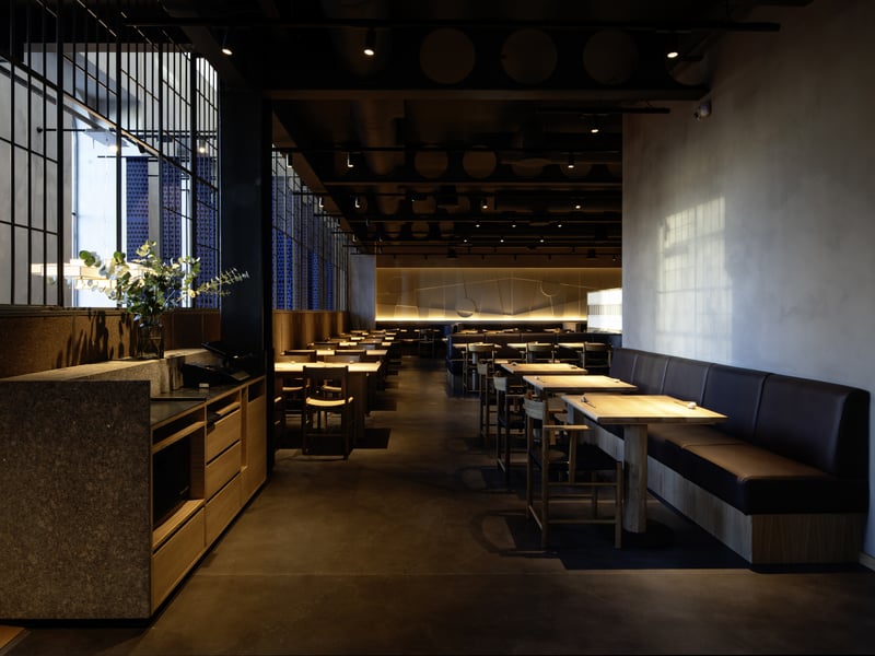 The spacious dining room features intricate light fixtures and large windows flood the room with light.