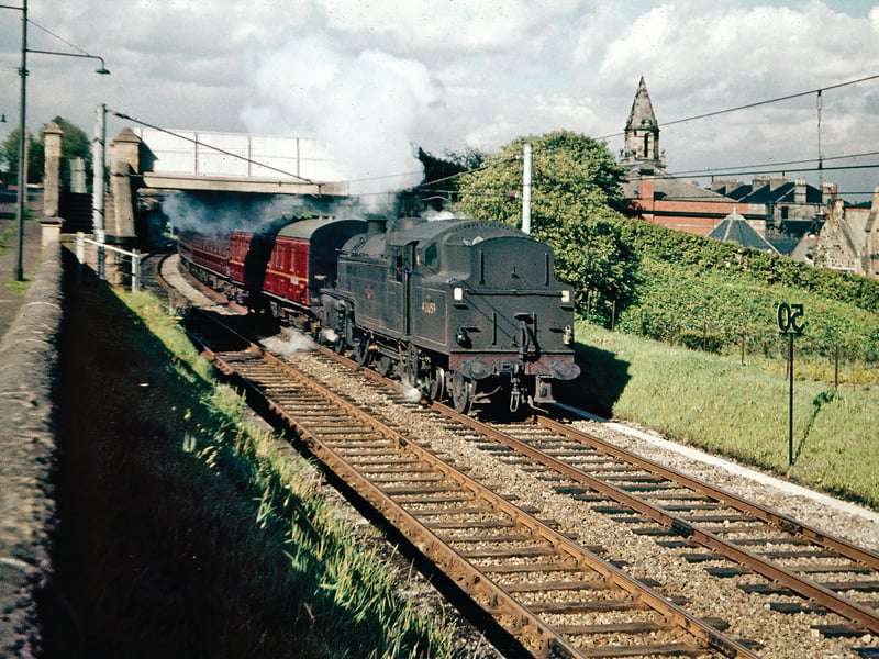 This photograph of a train for Neilston train passing by Monreith Road in Cathcart was taken just before steam-hauled services were replaced by electric trains on the South Side suburban routes. In the background is the Couper Institute, built with a legacy from a local papermaker