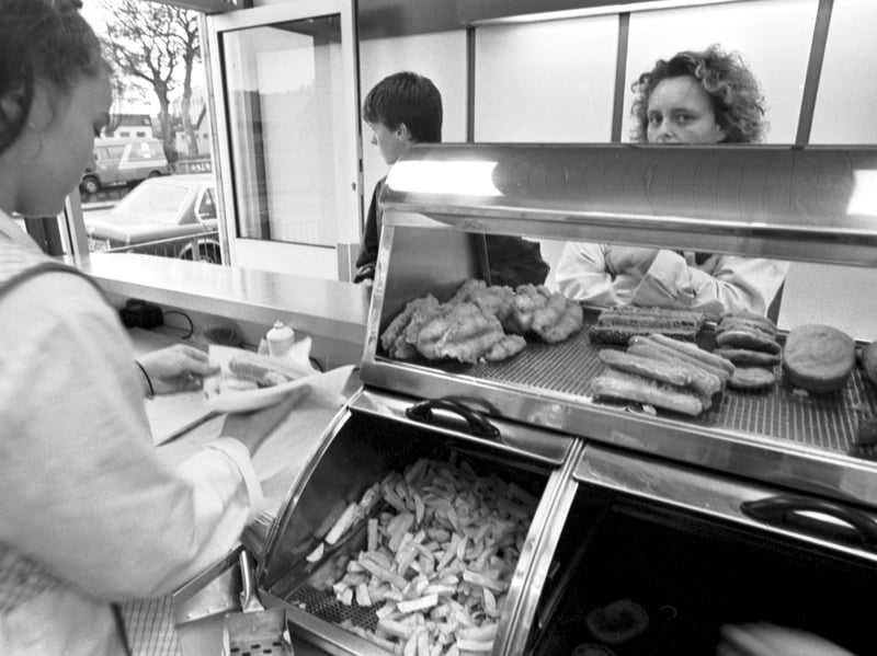 An assistant wraps a sausage supper for a customer at Remo's fish and chip shop in Glasgow in October 1992.