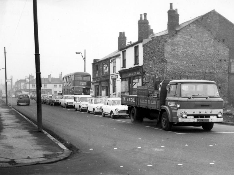 Meanwood Road in November 1968. Numbers 74 to 80 Meanwood Road, Leeds 7. The New Inn pub can be seen. A truck, a number 8 bus to Cottingley and many cars wait at the junction.