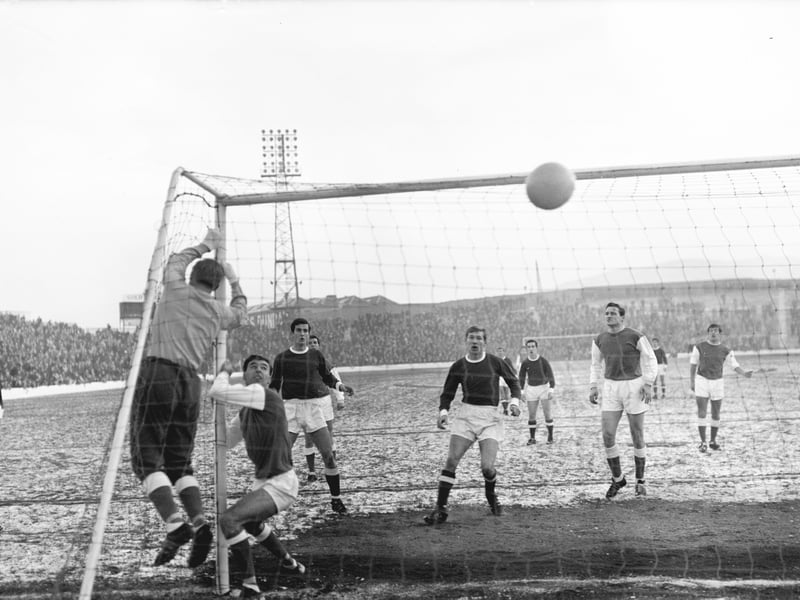 Hibs' goalkeeper Willie Wilson pushes the ball over the bar during a match against Dunfermline in November 1965. A young Sir Alex Ferguson can be seen playing for Dunfermline to the left of the picture.