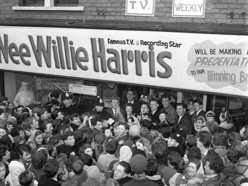 The crowd clamours to get a look at the TV and recording star 'Wee Willie' Harris during a visit to South Yorkshire in 1958. 'Wee Willie', who was known for his bright clothes and shock of red hair, was there to present the Bride of the Year prize at the Don and Dearne TV company in Goldthorpe.
