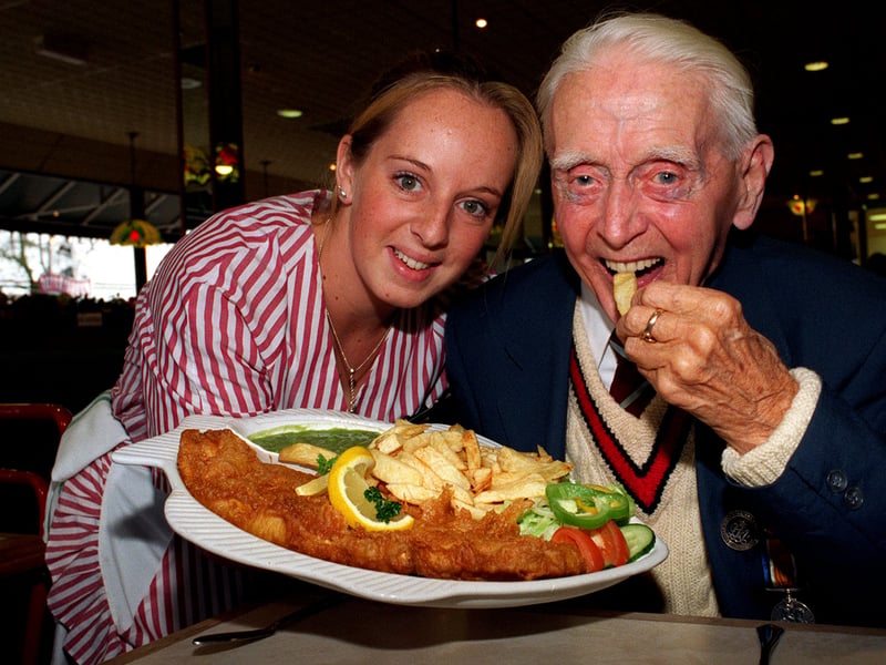 Waitress Nicola Nunns brings Harry Holme his fish and chips on his 100th birthday during celebration at Murgatroyds fish restaurant in November 1997.