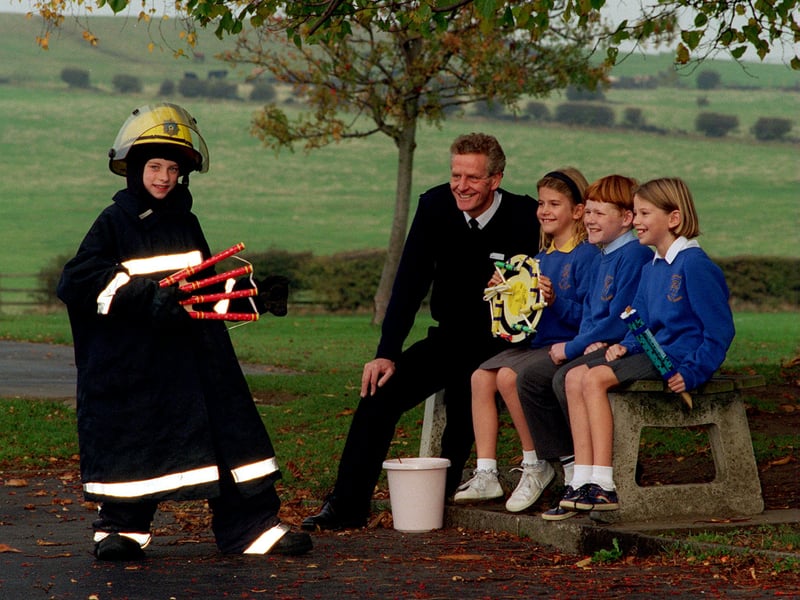 West Yorkshire Fire Service Fire Safety Officer John Naylor visited Rawdon C of E Primary to talk to children and parents about firework safety in October 1995. Pictured is Louise Davies seen here trying on a fire fighters uniform after the talk, watched by John Naylor and some of the other pupils, from left, Helen Cooban, Paul Hobbs and Jane Cooban.