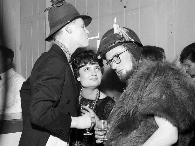 A Christmas reveller lights a cigarette from a candle at Edinburgh College of Art in 1962.