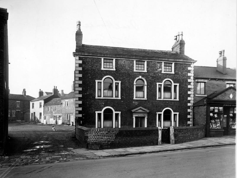 Chapel Street in November 1949. This view looks north west at numbers 3, 1, 4 and 5 Gravely Square and Dial House (number 12 Chapel Street). A hardware store is visible to the right. Dog can be seen sat in the square. A brick wall surrounds 'Dial House'.
