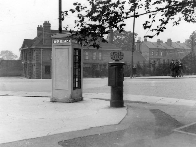 A telephone kiosk and letter box on corner of Harrogate Road and Montreal Avenue. Over the road is the Mexborough Arms public house. A young girl stands at a tram stop while a group of men are chatting by the side of the road. Pictured in July 1936.