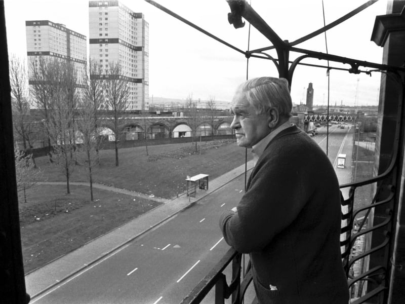 Pensioner John McMorran looks out at the multi-storey flats from the balcony of his home in one of the last tenements left in the Gorbals area of Glasgow, in April 1989