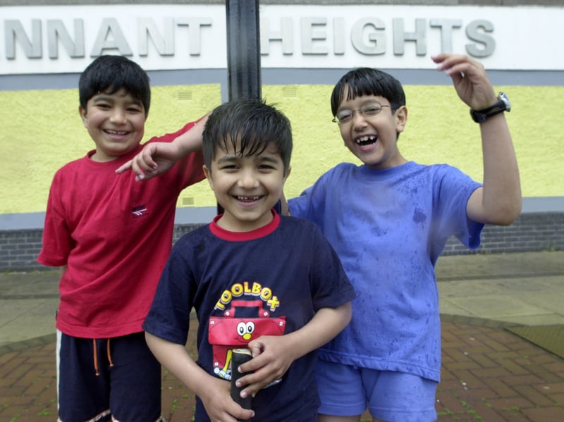 Three young asylum-seekers play cricket in the rain against one of the Sighthill tower blocks, Tennant Heights, in Glasgow, in 2001. Pictured are Suneel, 8, and younger brother Sameel, 5, from Afghanistan, and Radman, 8, from Iraq