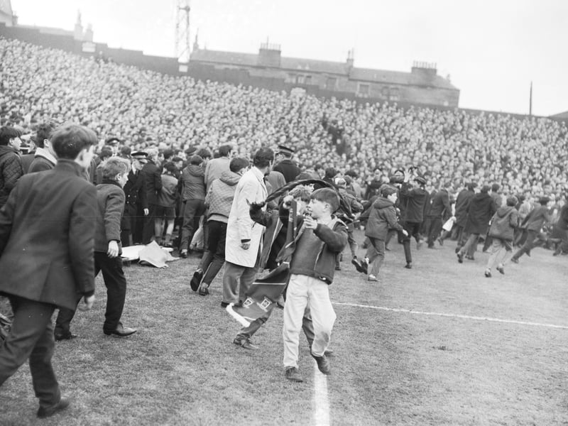 Police are swamped by supporters invading the pitch at Tynecastle Park during the Hearts versus Celtic match in March 1966.